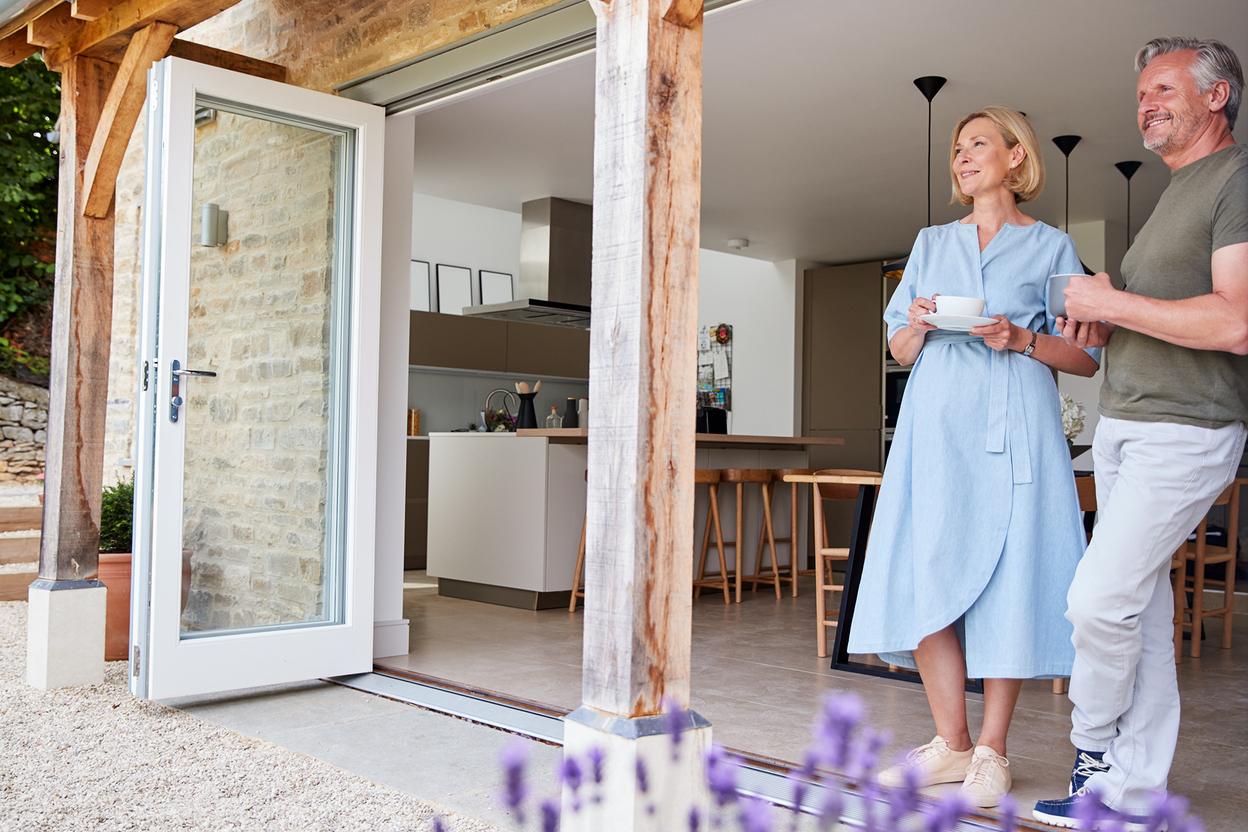 Paar steht in der Küche mit Zugang zum Garten
